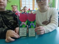 Dzieci z klasy trzeciej prezentują swoje papierowe laurki