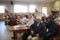Uczestnicy turnieju przy stole z szachami