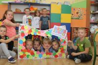 Grupa dzieci przedszkolnych pozuje do zdjęcia z kolorowa ramka