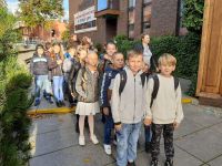 Grupa dzieci pozuje przez budynkiem teatru
