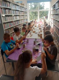 Grupa dzieci podczas zajęć plastycznych w bibliotece