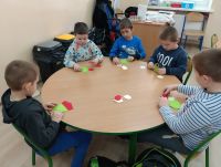 Dzieci z oddziału przedszkolnego przy stoliku podczas zajęć plastycznych