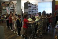 Dzieci oprowadzane wężykiem po bibliotece