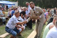 Wójt Gminy Wielgie częstuje uczestników chlebem dożynkowym