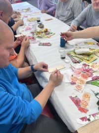 Mieszkańcy DPS-u wykonujący zakładki do książek metodą decoupage.