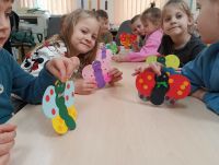 Dzieci prezentują papierowego motyla