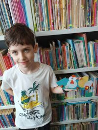 Uczeń prezentuje prace plastyczną w bibliotece
