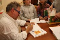 Autor składa autografy na książkach