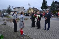 Złożenie kwiatów pod pomnikiem przez księży.