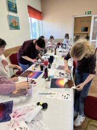 Uczestnicy warsztatów tworzący własne obrazy.