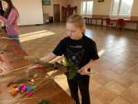 Uczestnicy zajęć tworzący własne palmy wielkanocne.