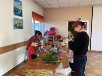 Uczestnicy zajęć tworzący własne palmy wielkanocne.