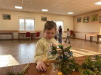 Uczestnicy zajęć tworzący własne palmy wielkanocne.