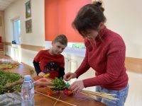 Uczestnicy zajęć tworzący własne palmy wielkanocne.