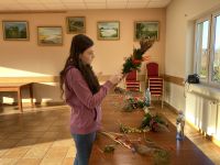 Uczestnicy zajęć tworzący własne palmy wielkanocne.