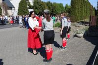 Zaproszeni goście składają kwiaty pod pomnikiem.