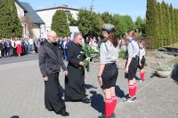 Złożenie kwiatów pod pomnikiem przez księży.